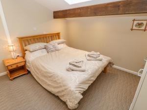 a bedroom with a bed with two towels on it at Carvin-Tor in Great Langton