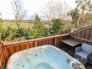 a jacuzzi tub on a deck with a table and chairs at Carvin-Tor in Great Langton