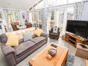 a living room with a couch and a flat screen tv at The Retreat in Narberth