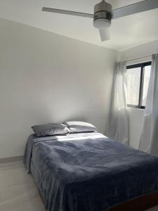 a white bedroom with a bed and a window at Casa Daniel in Ensenada