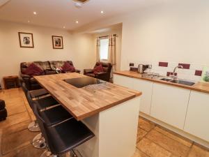 a kitchen and living room with a wooden counter top at The Stables in Chipping Norton