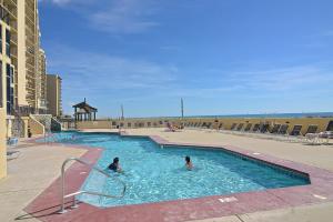 Dos personas están nadando en una piscina en Phoenix II 2067, en Orange Beach