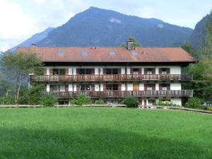 a large house with a green field in front of it at Ferienwohnung Dillmann in Sachrang