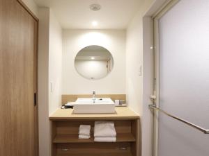 a bathroom with a sink and a mirror at Henn na Hotel Premier Nagoya Fushimiekimae in Nagoya +37 photos