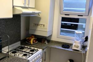 cocina pequeña con fogones y ventana en Las cañas Pinamar - Duplex 3 ambientes en Pinamar