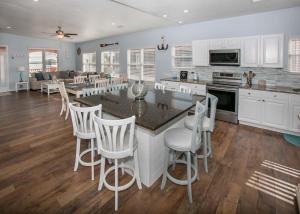 a kitchen with white cabinets and a table and chairs at Poseidon Palace in Sand Landing