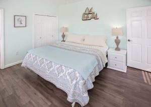 a white bedroom with a bed and two lamps at Poseidon Palace in Sand Landing +39 photos