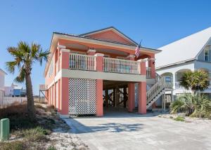 a house with a balcony and a palm tree at Poseidon Palace in Sand Landing