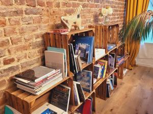 ein Stapel Bücher auf Holzregalen in einem Zimmer in der Unterkunft Brand new CAMELIA ROOM with private bathroom in Brüssel