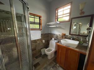 e bagno con servizi igienici, lavandino e doccia. di Hidden Treasure Vacation Home Blue Bay Cottage a Caye Caulker
