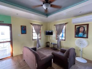 uma sala de estar com um sofá e uma ventoinha de tecto em Hidden Treasure Vacation Home Blue Bay Cottage em Caye Caulker