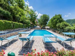 una piscina con tumbonas azules y una piscina con sauna en Belvilla by OYO Villa Artisti, en Piobbico