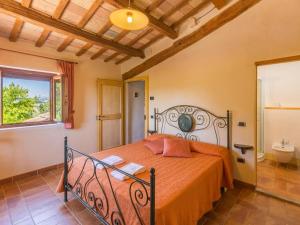 a bedroom with a bed with orange sheets and a bathroom at Belvilla by OYO Villa Fufi in Arcevia