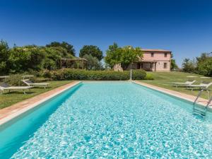 a swimming pool in a yard with a house at Belvilla by OYO Villa Fufi in Arcevia