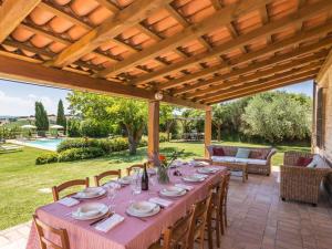 a table set for a meal under a wooden pergola at Belvilla by OYO Villa Fufi in Arcevia