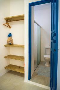 a bathroom with a toilet and a blue door at Villa Hortencia Trancoso in Trancoso