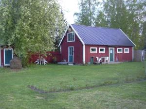una casa rossa con un tavolo da picnic di fronte di Ljugarn Holiday Home a Ljugarn