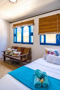 two beds in a room with blue windows at Villa Hortencia Trancoso in Trancoso