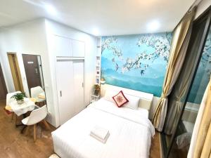 een slaapkamer met een wit bed en een schilderij aan de muur bij Căn hộ Studio Vinhomes Greenbay cho thuê in Hanoi
