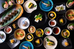a table topped with plates of food on top at Kyoto Yamashina Hotel Sanraku in Kyoto