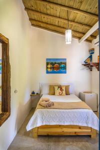 Cama en habitación con techo de madera en Villa Hortencia Trancoso, en Trancoso