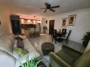 uma sala de estar com um sofá e uma ventoinha de tecto em Zona Dorada Suites em Mazatlán