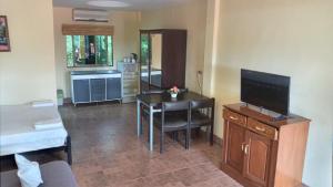 a living room with a table and a television at Phratamnak Inn - 100 meter from Beach in Pattaya South