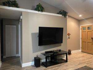 sala de estar con TV de pantalla plana en la pared en Cozy 3 bedrooms home close to everything in Tampa! en Tampa