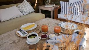 a coffee table with breakfast foods and drinks on it at Amai Luna in Máncora