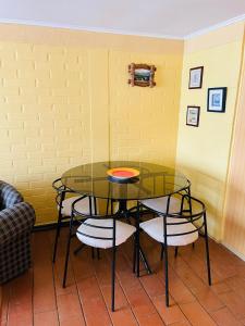 une table et des chaises avec une table en verre et une table dans l'établissement Cabaña Algarrobo, à Algarrobo