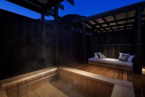 een veranda met 2 bedden op een houten terras 's nachts bij Hotel Zagakukan in Hakone