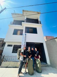 un grupo de personas de pie en frente de un edificio en Montañero Hostel, en Huaraz