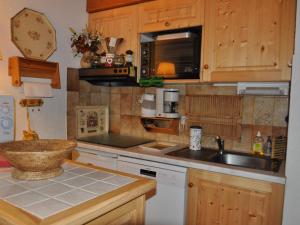 cocina con armarios de madera, fregadero y microondas en Appartement Châtel, 2 pièces, 6 personnes - FR-1-693-13, en Châtel