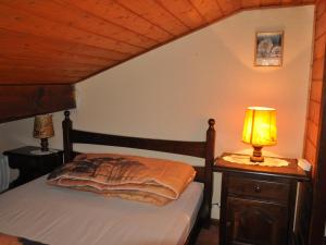 1 dormitorio con cama y mesita de noche con lámpara en Appartement Châtel, 2 pièces, 6 personnes - FR-1-693-13, en Châtel