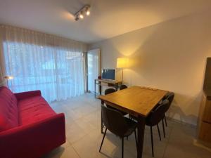 - un salon avec un canapé rouge et une table en bois dans l'établissement Appartement Châtel, 3 pièces, 6 personnes - FR-1-693-48, à Châtel