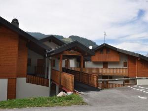 budynek z drewnianymi balkonami na parkingu w obiekcie Appartement cosy avec Multi Pass offert, à 10 minutes du centre de Châtel et proche des remontées - FR-1-693-7 w mieście Châtel