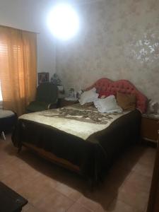 1 dormitorio con 1 cama con cabecero rojo en La casa de la Abuela en San Rafael