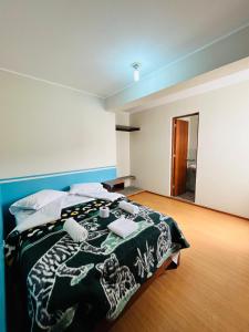 1 dormitorio con 1 cama con manta blanca y negra en Montañero Hostel en Huaraz