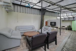 ein Wohnzimmer mit Sofas, einem Tisch und einem TV in der Unterkunft RedDoorz near RS Sari Asih Ciledug in Jakarta