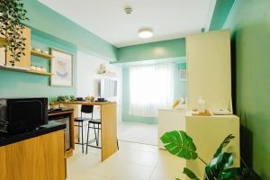 a living room with green walls and a kitchen at Vicar Home by Serin East Tagaytay in Tagaytay