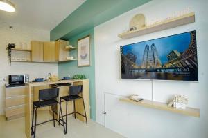 a kitchen with two stools and a tv on the wall at Vicar Home by Serin East Tagaytay in Tagaytay