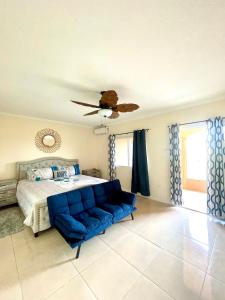 sypialnia z łóżkiem i niebieską kanapą w obiekcie My Palm Retreat w mieście Mammee Bay
