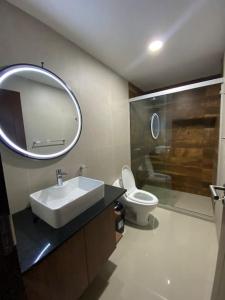 y baño con lavabo, aseo y espejo. en Departamento tres dormitorios, en Tarija