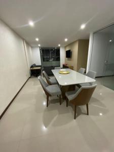 ein Esszimmer mit einem weißen Tisch und Stühlen in der Unterkunft Departamento tres dormitorios in Tarija