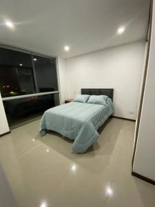 a bedroom with a bed in a white room at Departamento tres dormitorios in Tarija