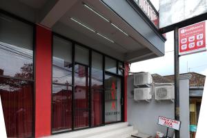 a store front with black and red windows on a street at RedDoorz near Alun Alun Magelang 2 in Magelang