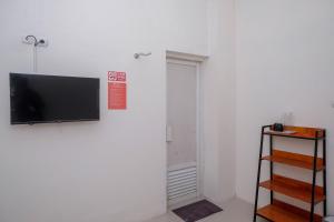 a flat screen tv hanging on a white wall at RedDoorz near Alun Alun Magelang 2 in Magelang