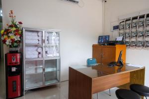 una oficina con escritorio y nevera en RedDoorz near Alun Alun Magelang 2 en Magelang