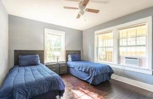 a bedroom with two beds and a ceiling fan at Cozy Yellow Home near LSU and Downtown in Baton Rouge