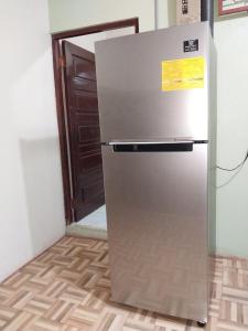 una nevera de acero inoxidable en una habitación con puerta en Apartamento AMUEBLADO en Canoas